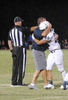 Assistant coach Jeremy Gage congratulates Brian Zhang after his fourth-quarter interception at Pauls Valley on Friday.