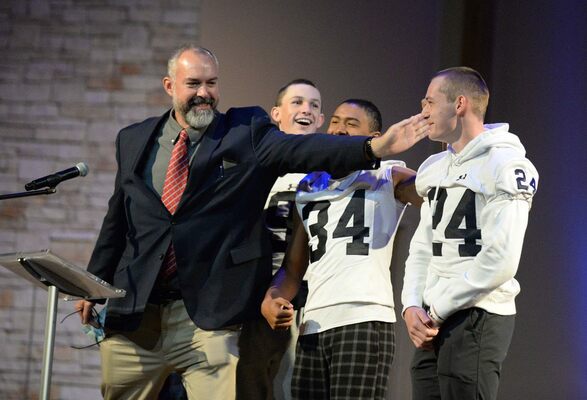 Marlow High School Principal Bryan Brantley has a bit of fun with some
of the Outlaw players, from left, Zach Pettit, King Harrison and Korbin
Dittner, following the Veterans Day assembly Friday at First Baptist
Church. Students voted with cheers and applause on who had the
best ‘buzzed’ haircut prior to the playoff game set for later that night.
Dittner was the clear winner. Kyler Blundell was also on stage, and is
hidden in this photo behind Brantley. 
Photo by Toni Hopper/The Marlow Review