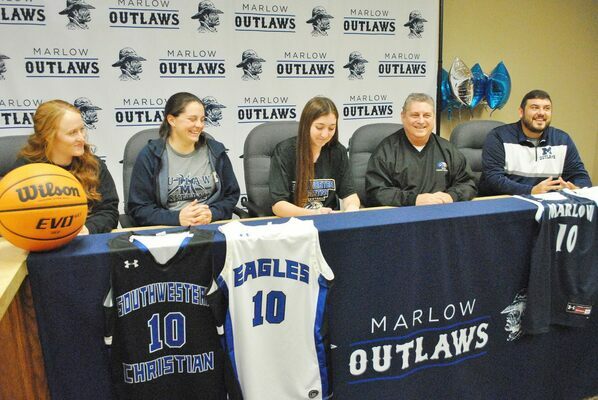 Marlow senior Whitney Wade, center, makes it official to play women’s basketball at Southwestern Christian University in Bethany, next fall. From left, SCU Women’s Basketball Coach Andi Rollins, MHS Coach Brett Tahah, Wade, SCU Head Coach Mark Arthur, and MHS Assistant Coach Scott Tahah. Wade’s parents and both sets of grandparents, her high school teammates and friends were all present for the event. 
Photo by Toni Hopper/The Marlow Review