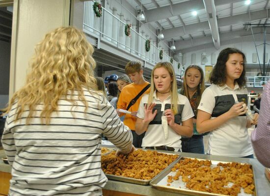 Marlow High School FFA officer, Katy Diedrich, appears to be passing on having calf fries added to her plate at the annual Labor Auction and meal, Thursday, Dec. 1, 2022. Photo by Toni Hopper/The Marlow Review