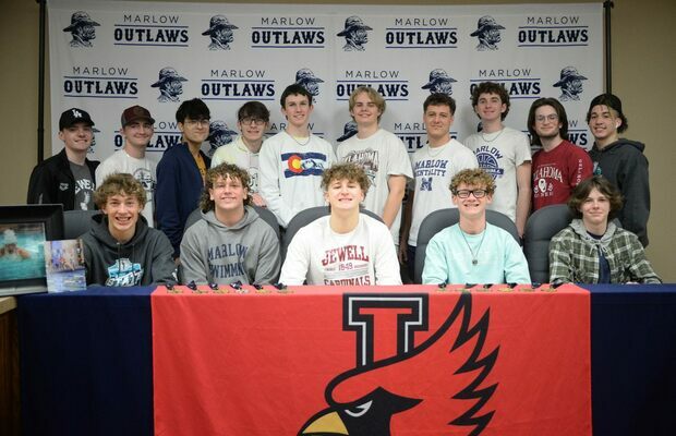 Gage, center in white, is surrounded by all of his teammates, from swimming and Cross Country, during his signing at the Marlow School district office, Monday, Feb. 20, 2023. Photo by Toni Hopper/The Marlow Review
