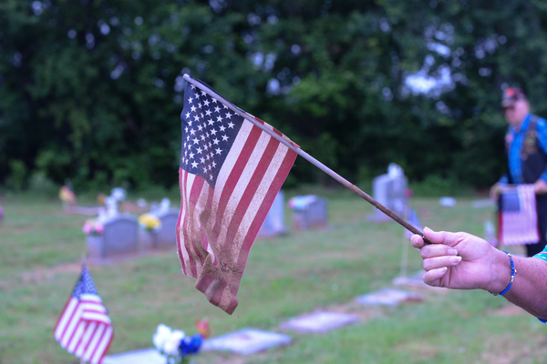 Pat Lavey, wife of Earl, displays one of the small gravestone American flags being replaced Saturday, May 27, 2023, at Marlow Cemetery. Photo by Toni Hopper/The Marlow Review