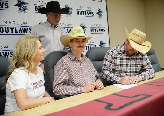 Korben Baker grins as his mother, Monica, and Fort Scott Community College Coach Chad
Cross watch Kenny Baker add his signature to the official intent letter for the high school senior, who will head to Kansas to compete as a rodeo athlete after graduation. 
Photo by Toni Hopper/The Marlow Review