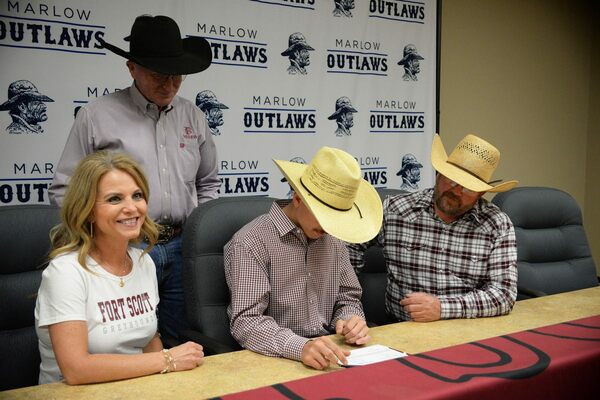 Korben Baker examines his national intent letter as his parents Kenny and Monica watch as Fort Scott Community College Coach Chad Cross oversees the official moment.
Photo by Toni Hopper/The Marlow Review